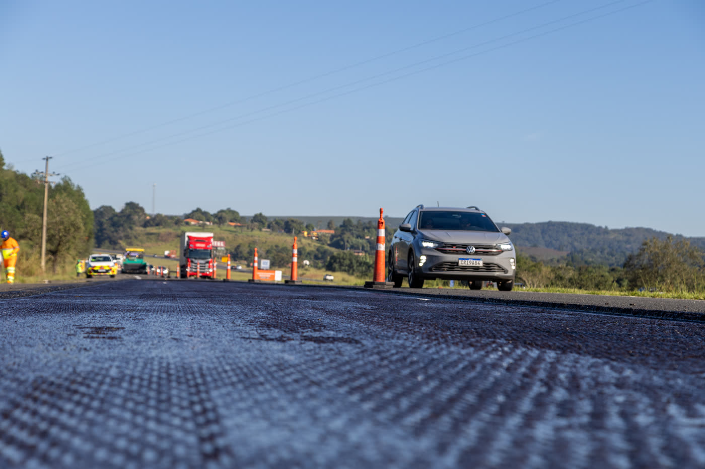 Pavimentação da SP-258 em Itapeva, vista em nível de pista com tráfego passando