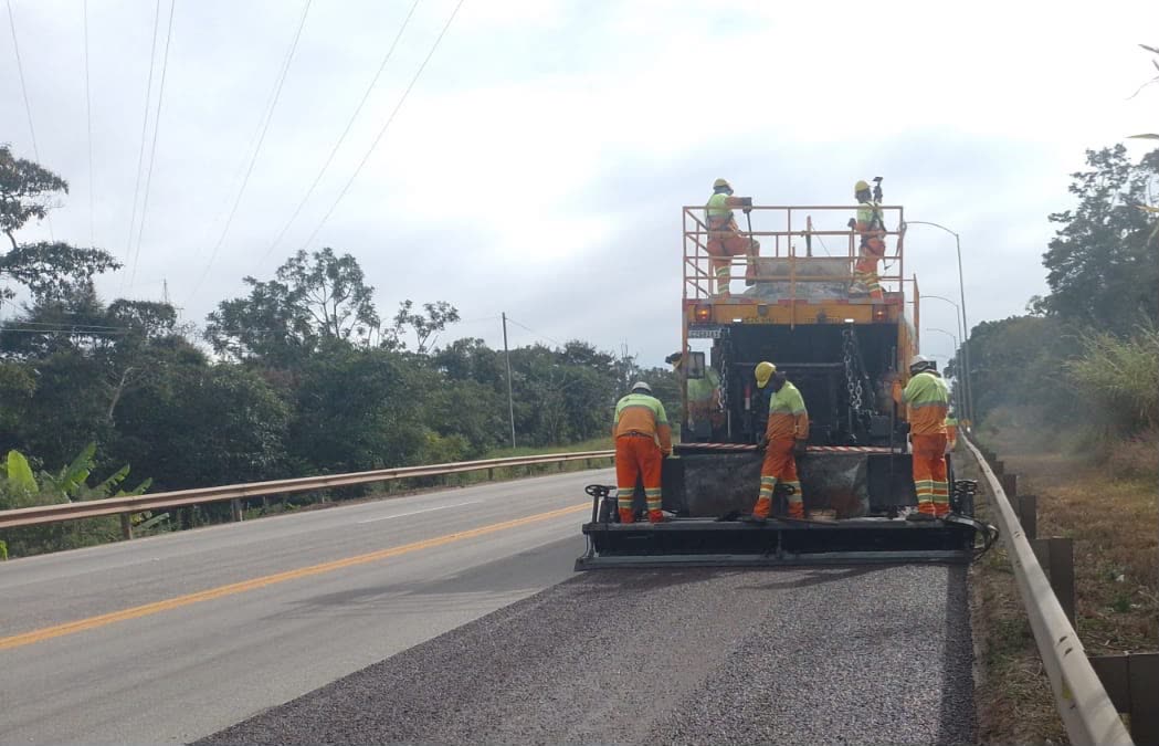 Equipe realizando pavimentação com equipamento na BR-040