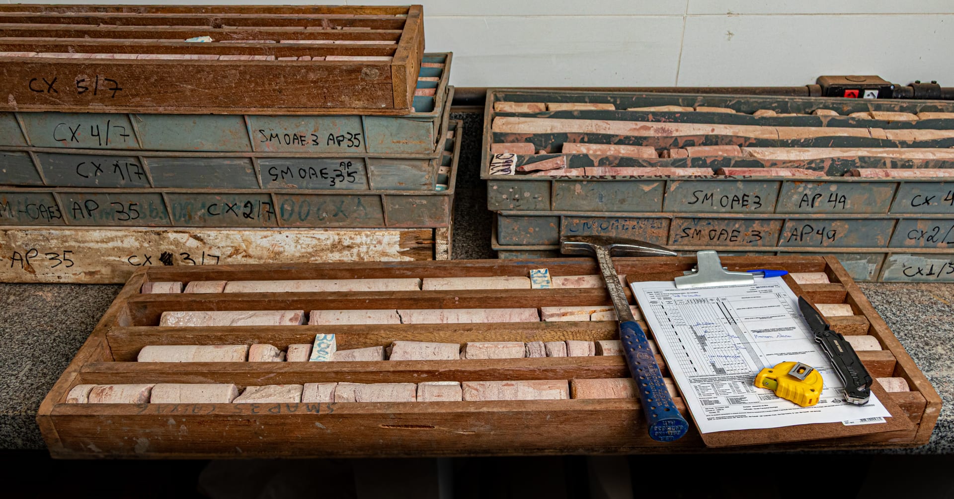 Caixas de testemunhos organizadas e identificadas para descrição e classificação - Suporte Geologia