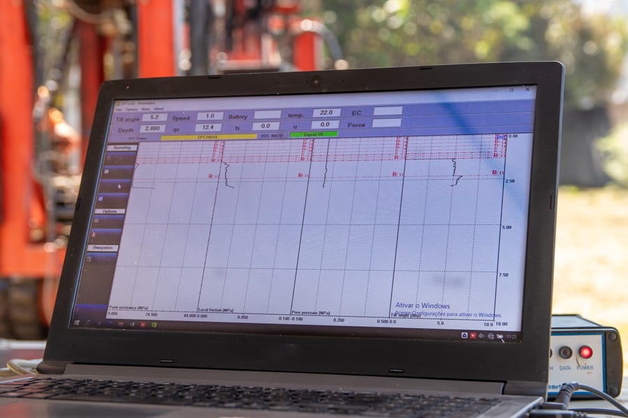 Tela de leitura em tempo real de ensaio de campo em notebook, próxima ao equipamento de sondagem