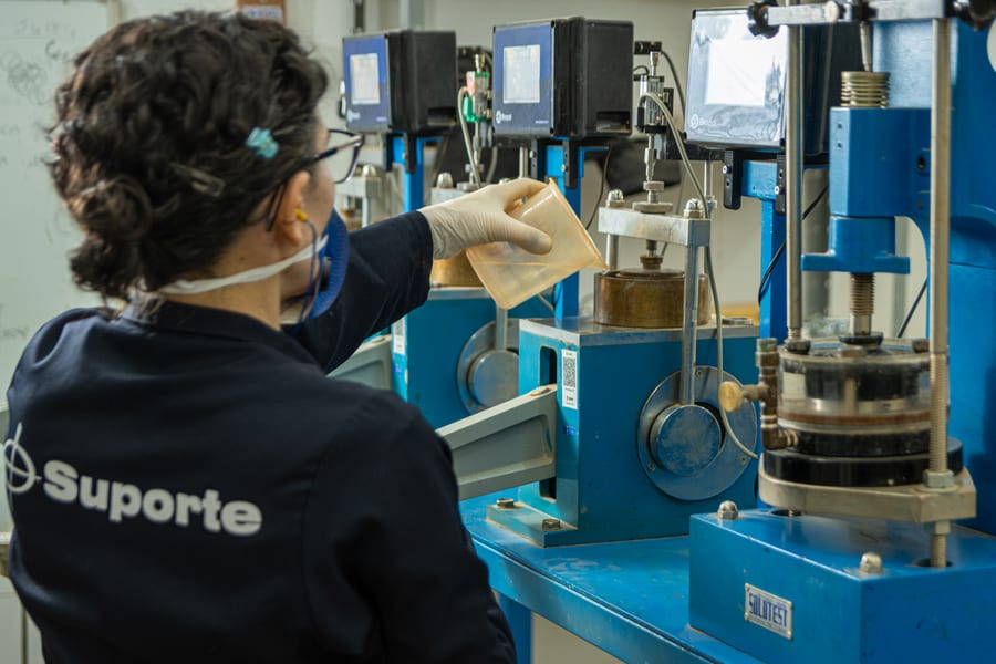 Técnica da Suporte conduzindo ensaio de adensamento em laboratório para caracterização de solo mole